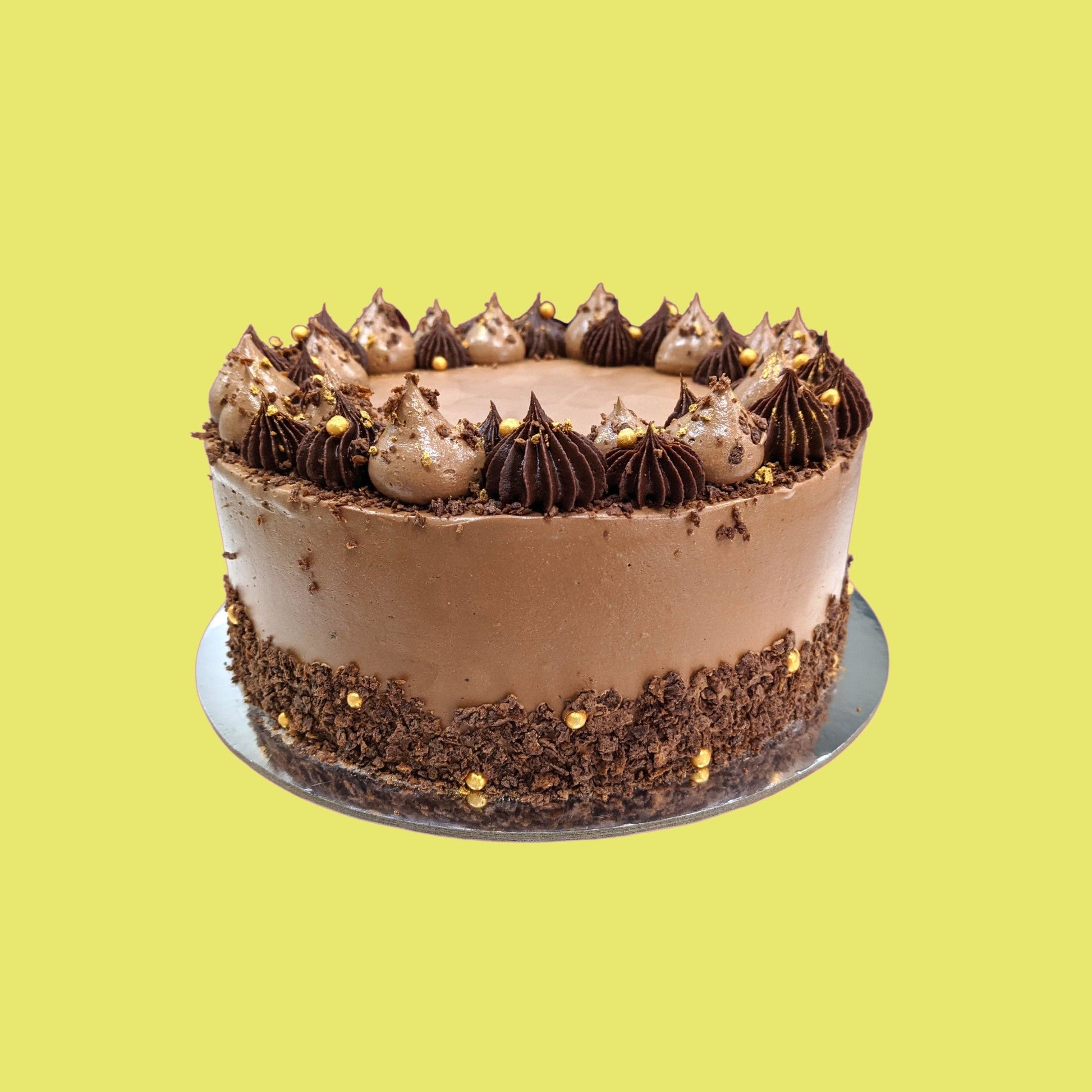 Chocolate cake with chocolate buttercream, biscuit crumb and gold sprinkles